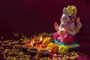 lâmpadas diya de argila acesas com o senhor ganesha durante a celebração do diwali. projeto de cartão de saudações festival indiano da luz hindu chamado diwali foto