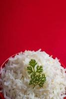 arroz basmati branco puro cozido em uma tigela vermelha sobre fundo vermelho foto
