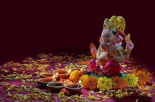 lâmpadas diya de argila acesas com o senhor ganesha durante a celebração do diwali. projeto de cartão de saudações festival indiano da luz hindu chamado diwali foto