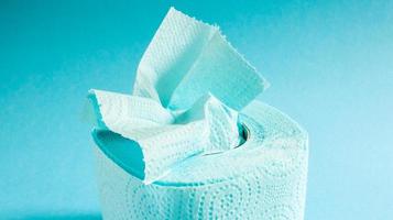 rolo azul de papel higiênico moderno em um fundo azul. um produto de papel em uma manga de papelão, usado para fins sanitários de celulose com recortes para facilitar o rasgo. desenho em relevo foto