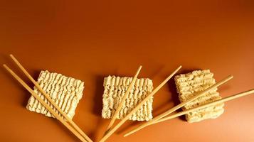 macarrão instantâneo seco cru com pauzinhos com espaço de cópia. comida asiática. minimalismo. macarrão, para a preparação da qual basta derramar água fervente e esperar alguns minutos. aletria, espaguete foto