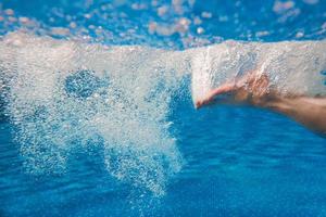 pernas masculinas nadando debaixo d'água na piscina no verão foto