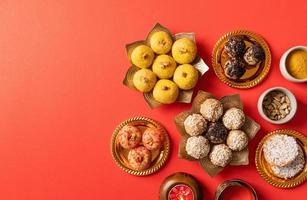 doces indianos tradicionais em plano de fundo vermelho foto