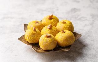 doces indianos tradicionais laddu em fundo de concreto foto