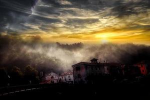 belo pôr do sol de um vermelho ardente com tons de amarelo dourado com nuvens refletindo essas cores esplêndidas do sol foto