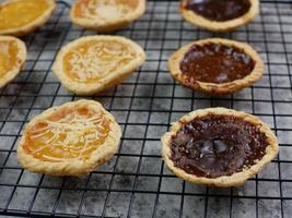 tortas com sabor de abacaxi, queijo e chocolate em uma grade de resfriamento. conceito de comida de padaria foto