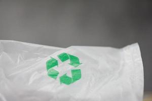 mundo de plástico ou conceito de dia mundial do meio ambiente - logotipo de reciclagem verde em um saco de plástico reduz a sacola de compras do conceito de desperdício zero ambiental foto