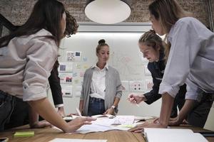 a equipe de colegas de trabalho e o colega fizeram um brainstorm, discutindo uma estratégia de marketing, colaboração de ideias e planejamento de projeto de negócios em uma mesa de conferência de escritório no local de trabalho de reunião de equipe. foto