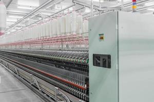 máquinas e equipamentos na oficina para a produção de fios. fábrica têxtil industrial foto