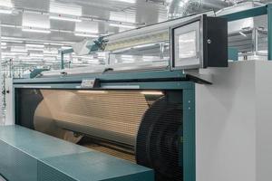 máquina evapora o fio têxtil. máquinas e equipamentos em uma fábrica têxtil foto