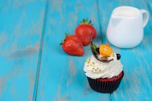 deliciosos bolos frescos com frutas e creme branco sobre um fundo azul foto