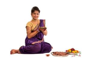 retrato de uma menina indiana tradicional segurando uma foto de diya, diwali ou deepavali com mãos femininas segurando uma lâmpada a óleo durante o festival de luz sobre fundo branco