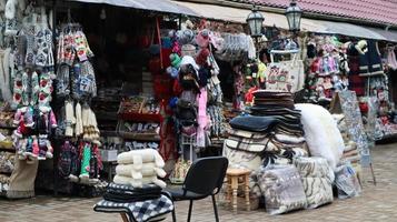 mercado de souvenirs em yaremche com roupas tradicionais artesanais dos Cárpatos, ervas e ferramentas de madeira. têxteis ucranianos, meias de malha, coletes, chapéus. ucrânia, yaremche - 20 de novembro de 2019 foto