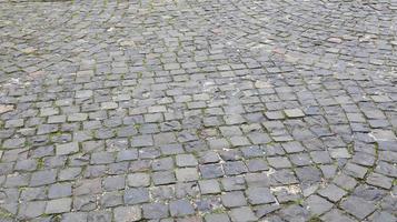 vista lateral dos paralelepípedos da rua. foto detalhada da superfície da estrada. obras de arte tradicionais nas estradas e calçadas da parte antiga da cidade.