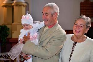 retrato de velho pai com neta durante o batismo na igreja foto