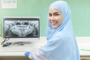 retrato de dentista muçulmana feminina trabalhando em clínica odontológica, check-up de dentes e conceito de dentes saudáveis foto