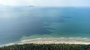 belo mar no parque nacional laem son, ranong, tailândia. na área do porto de pesca local e fundo da bela costa natural por vista aérea do drone. foto