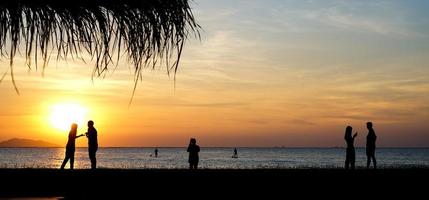 chonburi, tailândia 2021 - silhueta de pessoas na praia sunet foto