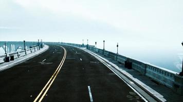 estrada de asfalto e montanha em nevoeiro profundo foto