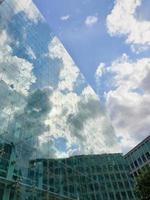 reflexo do céu azul e nuvens na fachada de vidro de edifícios modernos no distrito de spinningfields de manchester, reino unido foto