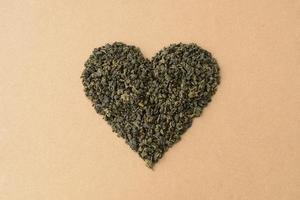 forma de coração feita de folhas de chá verde chinês. leite oolong, chá fermentado. coração de amor, dia dos namorados foto
