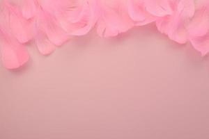 penas cor de rosa brilhantes em um fundo rosa claro. lindo papel de parede abstrato dia dos namorados, amor foto