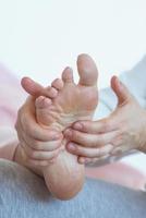 mãos fazendo massagem tailandesa nos pés. medicina alternativa e conceito de massagem tailandesa foto