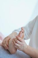 mãos fazendo massagem tailandesa nos pés. medicina alternativa e conceito de massagem tailandesa foto