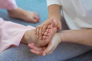 mãos fazendo massagem tailandesa nos pés. medicina alternativa e conceito de massagem tailandesa foto