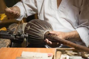 mestre adulto restaura instrumentos musicais antigos. produção de instrumentos de cordas foto