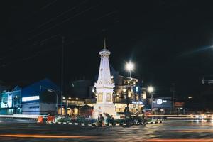 tugu jogja ou monumento yogyakarta, indonésia. tirada à noite com trilha de semáforo de veículos. foto
