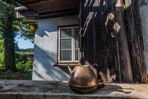 bule de cobre no terraço de uma casa abandonada foto