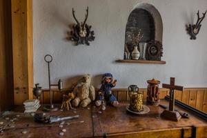 pistola de bonecas e velas em um armário de uma casa abandonada foto