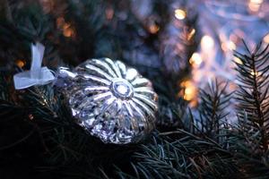 brinquedo de natal, bola de prata no galho de árvore de natal. espaço de cópia foto