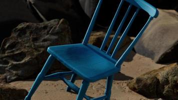 cadeira de madeira azul retrô na praia foto