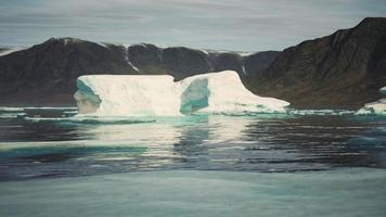 montanhas cobertas de neve contra o oceano azul na Antártida foto