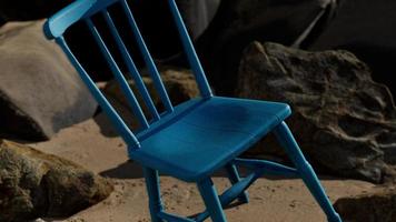cadeira de madeira azul retrô na praia foto