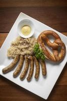 refeição bávara alemã tradicional de salsichas com chucrute e pretzel foto