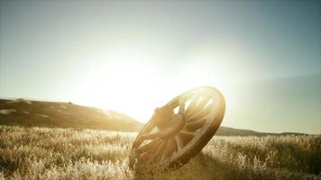 roda de madeira velha na colina ao pôr do sol foto