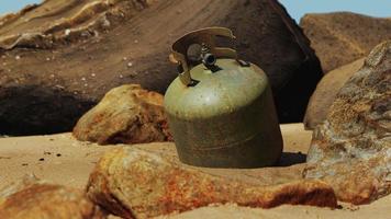 cilindro de gás de cozinha antigo na praia de areia foto