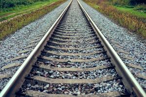 linha de via férrea indo para a distância, trilho de trem com pedra britada, dois trilhos paralelos foto