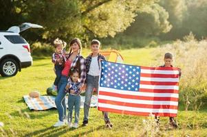 família americana. mãe e quatro filhos. com bandeiras dos EUA. américa comemorando. foto