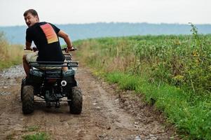 homem dirigindo quadriciclo quadriciclo de quatro rodas. foto