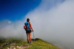 uma garota parece longe no nevoeiro no vale da montanha durante uma caminhada foto