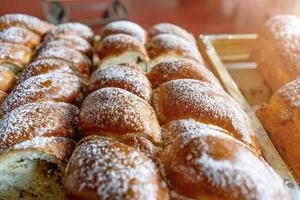 pãezinhos de farinha fresca polvilhados com açúcar em pó por cima acabados de sair do forno foto