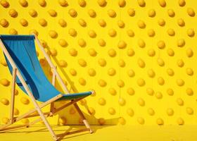 cadeira de praia azul em fundo amarelo foto