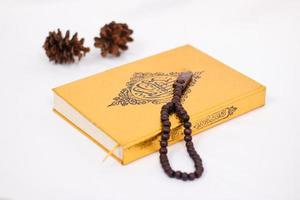 livro sagrado alcorão e tasbih isolados no fundo branco foto