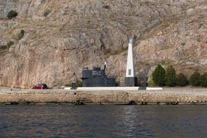 balaklava, crimeia-19 de outubro de 2017-paisagem com um monumento no fundo das rochas perto da costa. foto