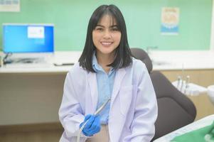 dentista feminina segurando uma sonda odontológica e um espelho verificando paciente na clínica odontológica, check-up de dentes e conceito de dentes saudáveis foto