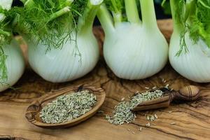 bulbos de erva-doce verde e branco em madeira de oliveira foto